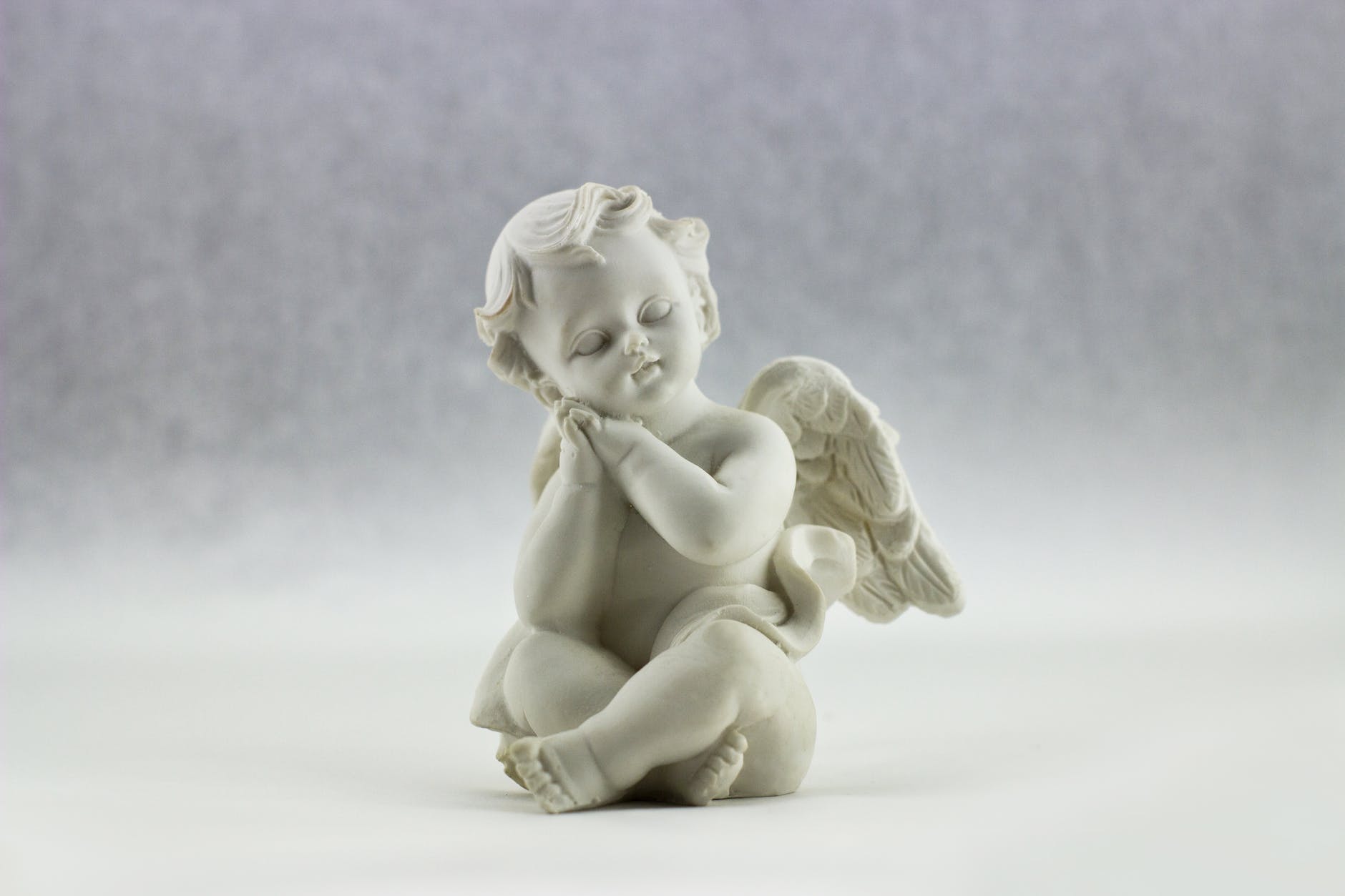 white ceramic figurine of angel illustration