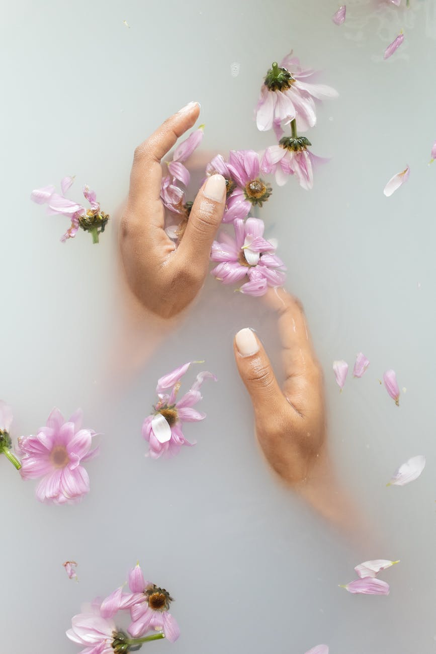 woman touching gentle flowers in water