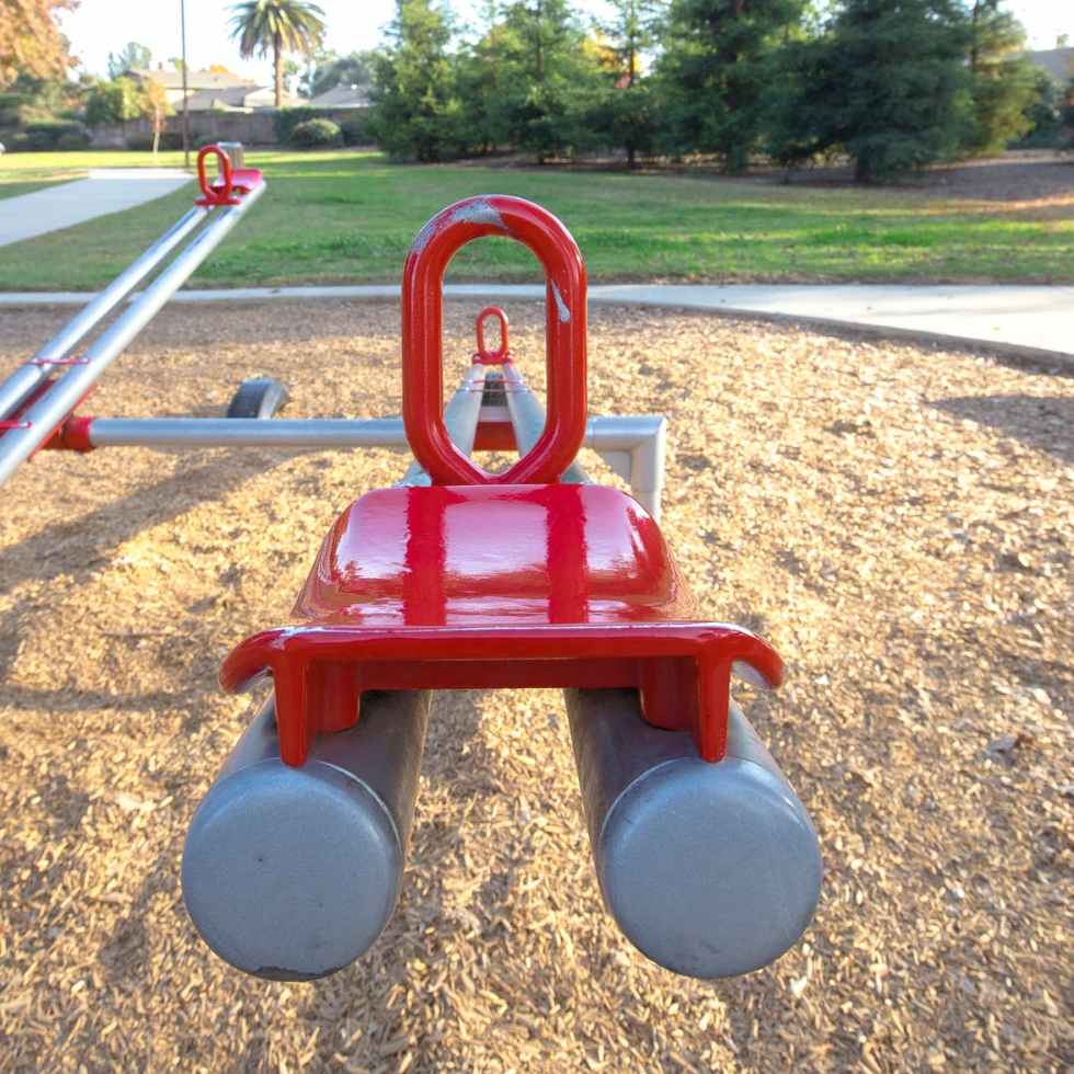 red and gray seesaw in the playground