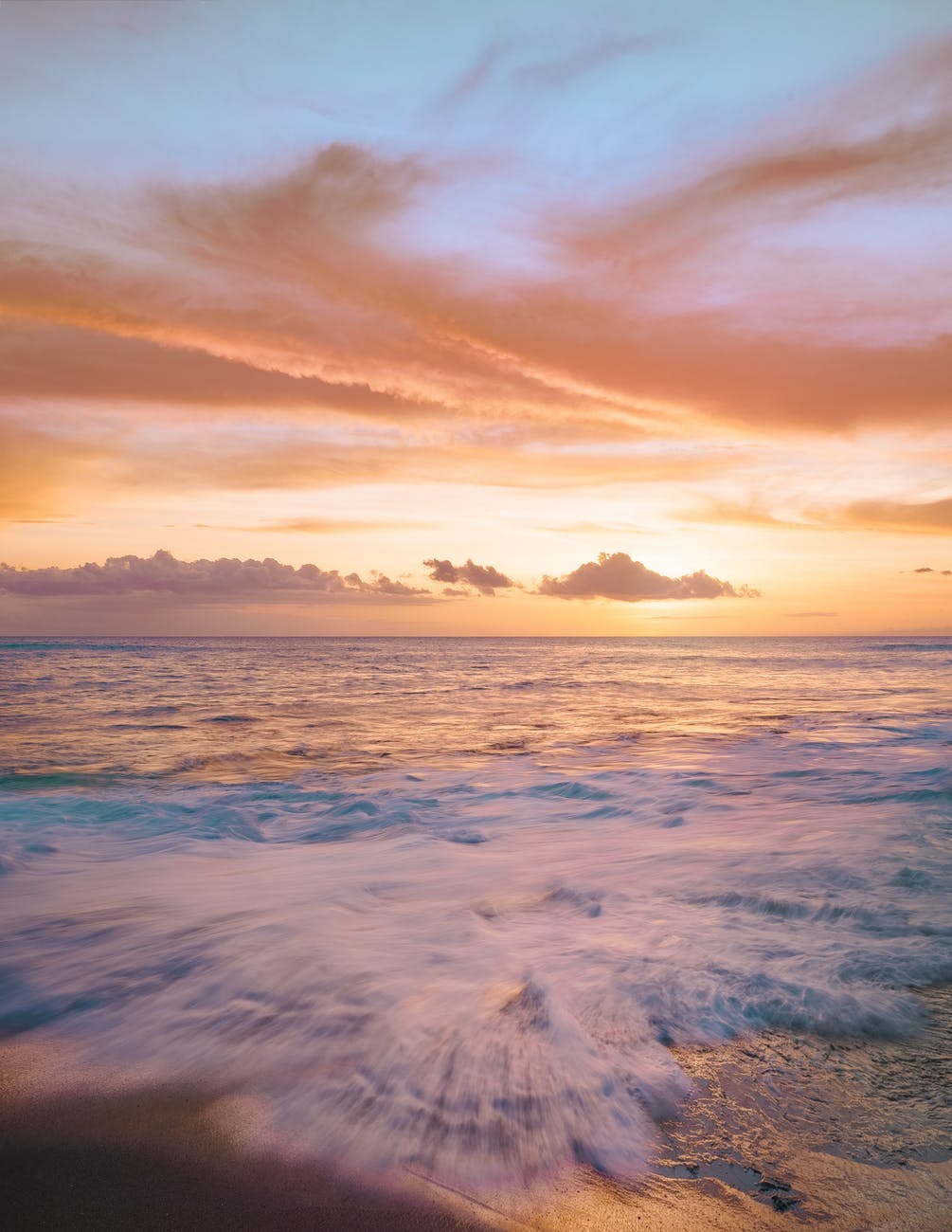 sea waves crashing on shore during sunset