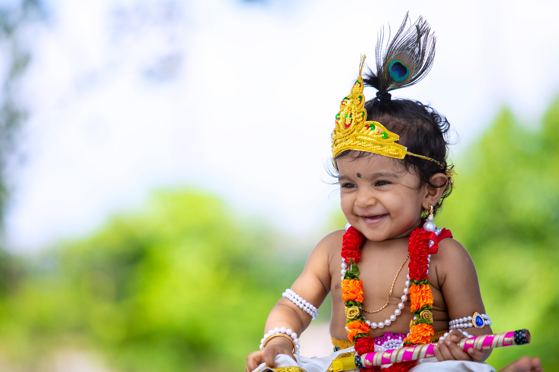 happy little ethnic girl in krishna costume in garden