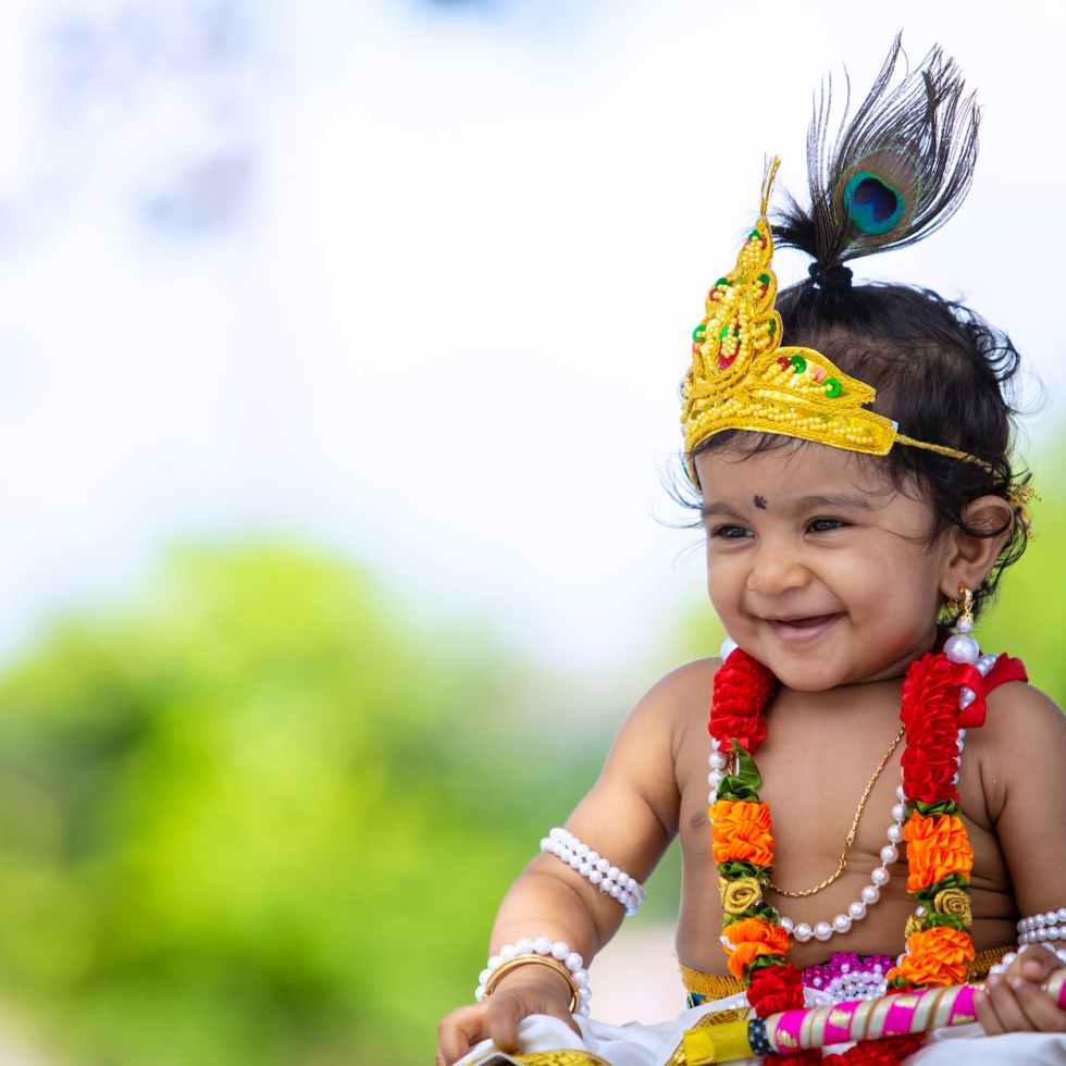 happy little ethnic girl in krishna costume in garden