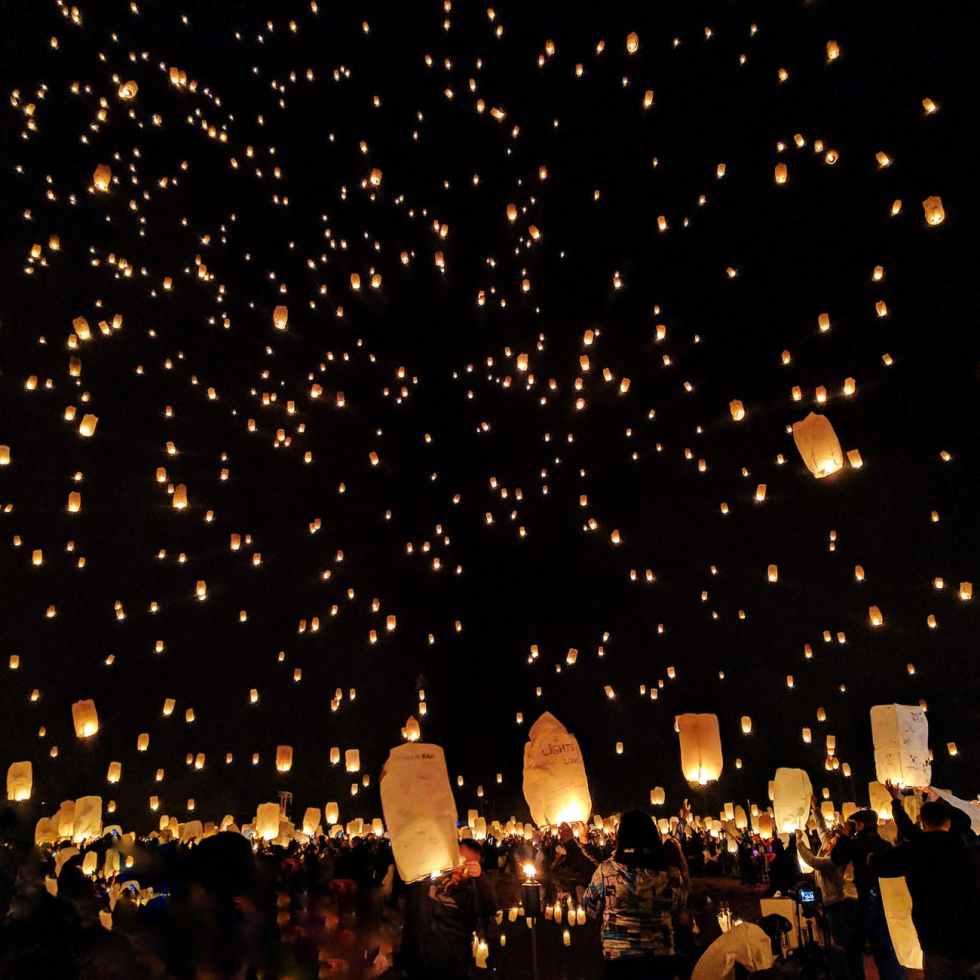 group of people throwing paper lantern on sky during night